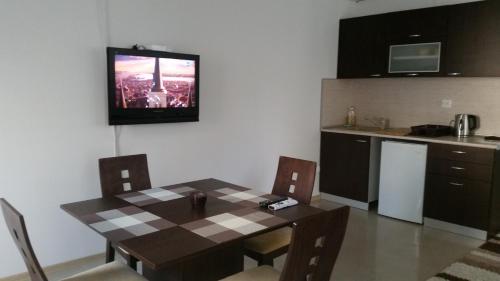 kuchnia ze stołem i telewizorem na ścianie w obiekcie 4U Apartment w Burgas