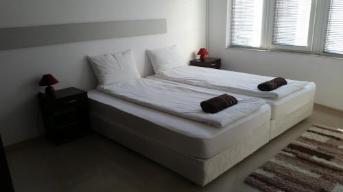 1 cama blanca con 2 almohadas en el dormitorio en 4U Apartment, en Burgas