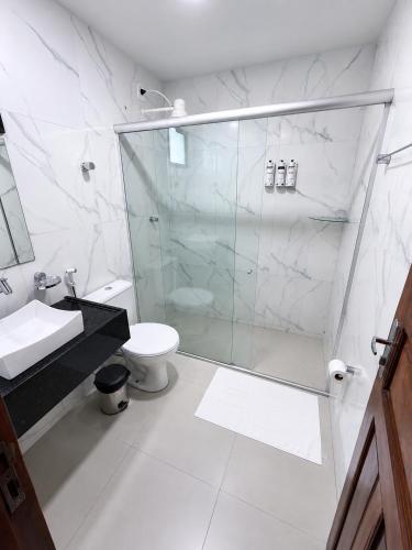 a bathroom with a glass shower and a toilet at Picos Hotel in Picos