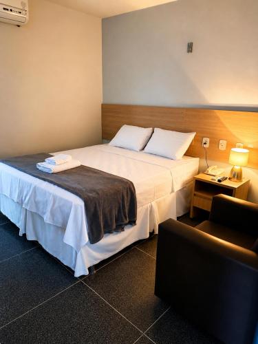 a hotel room with a large bed and a couch at Picos Hotel in Picos