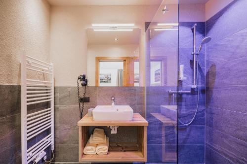 a bathroom with a sink and a shower at Alpinium - inklusive SUPER SOMMER CARD in Fiss