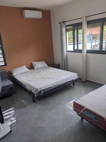 a bedroom with two beds and a window at Ambourvi in Mahajanga