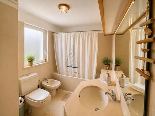 a bathroom with a sink and a toilet and a tub at Troia Apartments in Troia