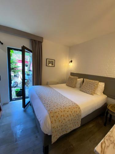 a bedroom with a large bed and a large window at Storytellers Boutique Villas in Sintra