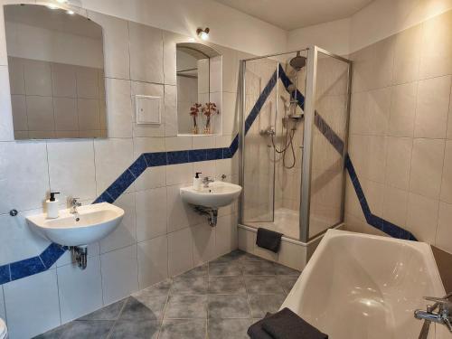 a bathroom with two sinks and a shower and a tub at Ferienhaus Zur alten Korbmacherei in Freyburg