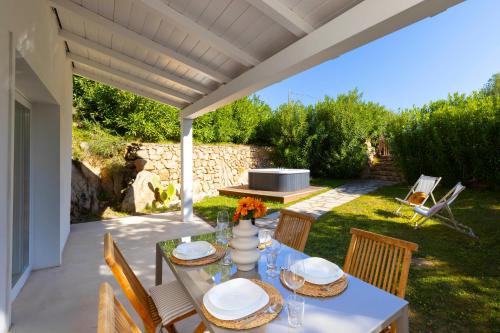 a patio with a table and chairs under a pergola at MH Suites in Olbia