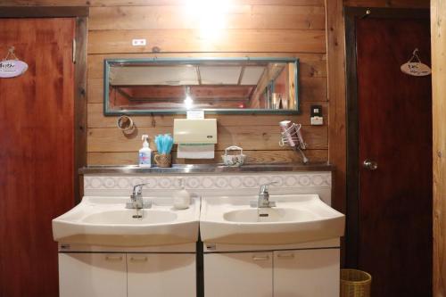 a bathroom with two sinks and a mirror at Yamagata Zao Pension Apron Stage in Kaminoyama