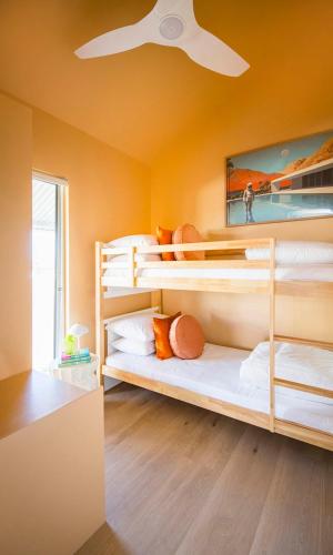 a room with three bunk beds with a ceiling fan at Trentham Waters Resort in Gol Gol