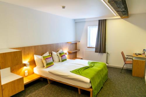 a hotel room with a large bed in a room at Kloster Heidberg in Eupen