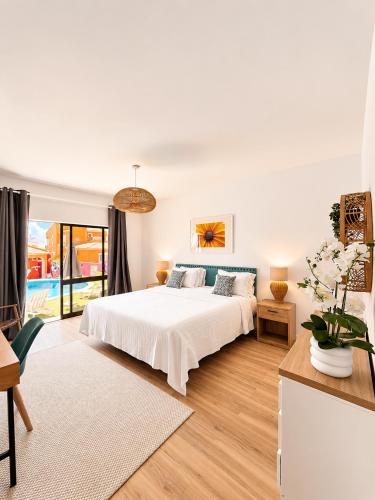 a white bedroom with a bed and a table at Casa Concha - Peaceful and Relaxing in Lagos