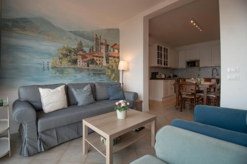 a living room with a blue couch and a painting at Casa di Emilia Iseo in Predore