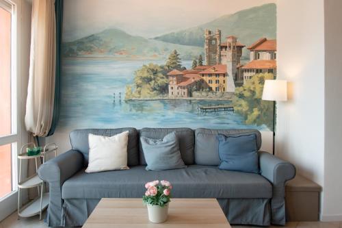 a living room with a blue couch in front of a painting at Casa di Emilia Iseo in Predore