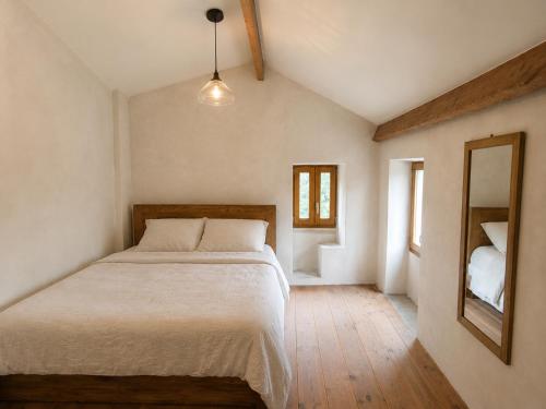 a bedroom with a large bed and a mirror at Domaine l Alba Scelta in Ucciani