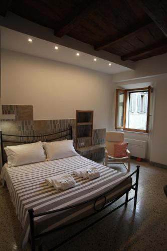 a bedroom with a large bed and a chair at Casa Dante in Vitorchiano