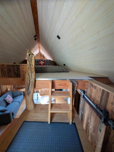 a room with a bed and a couch in a tiny house at la Petite Grange Escouaraou in Melles
