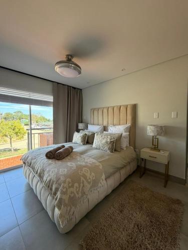 a bedroom with a large bed with a large window at SixtyOneAt1- George Central in George