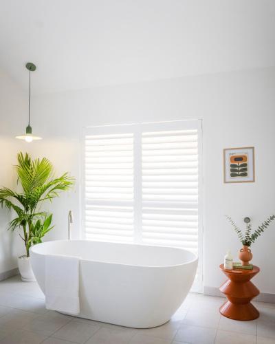 a white bath tub in a bathroom with a window at Trentham Waters Resort in Gol Gol