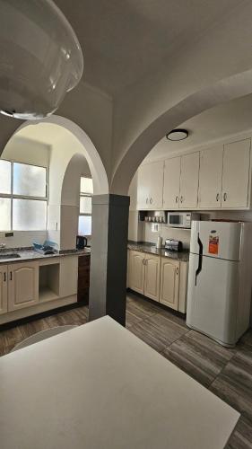 a kitchen with white cabinets and a white refrigerator at En Espejo in Mendoza