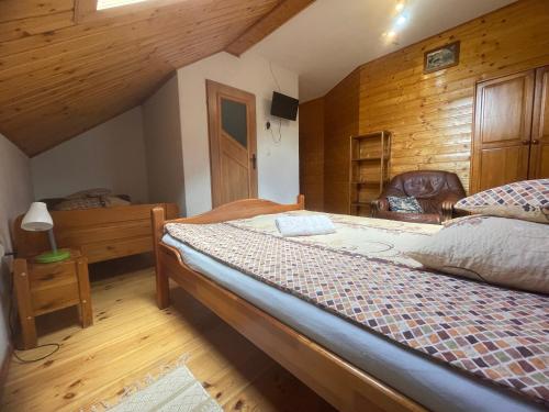 a bedroom with two beds and a wooden wall at Agroturystyka Świt dobry in Strzebowiska