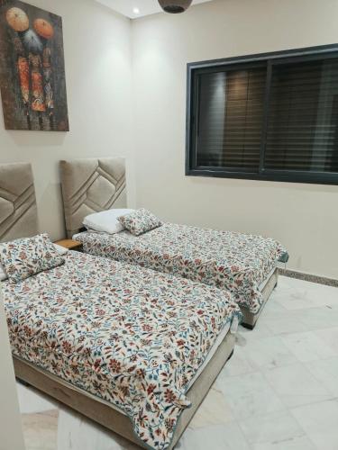 two beds sitting next to each other in a room at App najoua in Safi