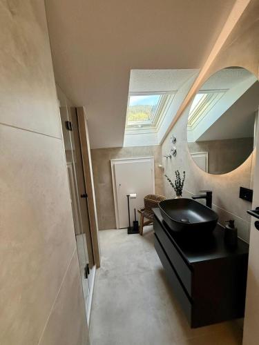 a bathroom with a black sink and a skylight at Bergheimat Stüble Allgäu in Bad Hindelang
