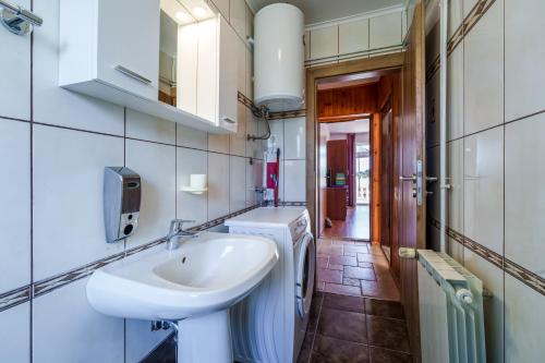 a bathroom with a sink and a washing machine at Apartments Anka in Krk