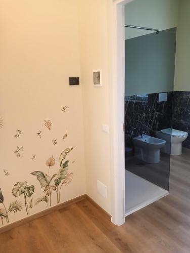 a bathroom with a shower with a toilet and butterflies on the wall at Sleep & Fly Villa Ornella in Case Nuove