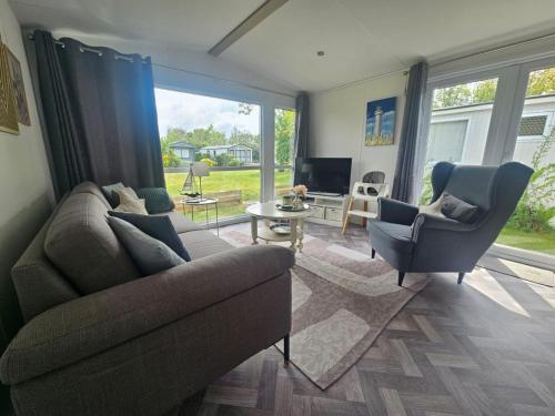 a living room with a couch and two chairs at Chalet 82 in Petten