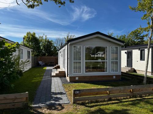 a garden office with a pitched roof at Chalet 82 in Petten
