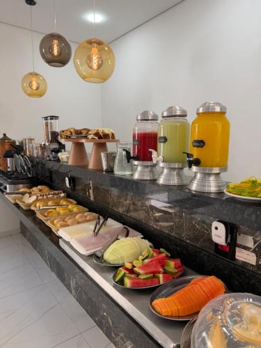 ein Buffet mit vielen Tellern mit Speisen und Getränken in der Unterkunft Hotel Pousada Colliseu in Aparecida