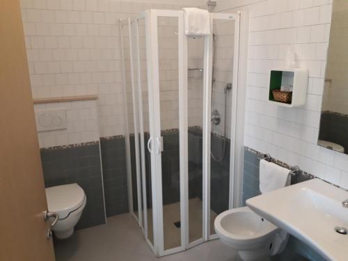 a bathroom with a shower and a toilet and a sink at Hotel Villa Enea in Cattolica