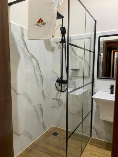 a bathroom with a shower and a sink at Peak Park Hotel in Mbeya