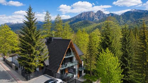 an aerial view of a house with mountains in the background at Tatry Residence SPA in Kościelisko