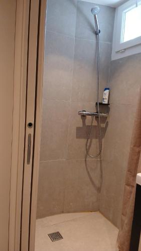 a shower with a shower head in a bathroom at Luxury Studio - Romainville in Romainville