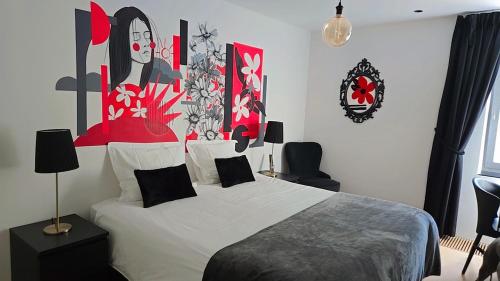 a bedroom with a bed with red and black art on the wall at Les Chambres des Lisières d'Havré - Chambres d'hôtes in Mons