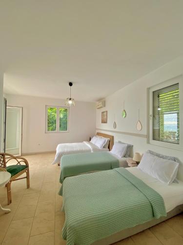 a room with three beds and a table and chairs at Budva Sky Sea - View Point in Budva