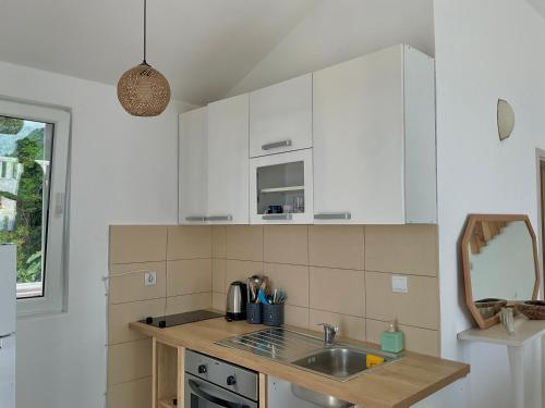 a kitchen with white cabinets and a sink at Budva Sky Sea - View Point in Budva