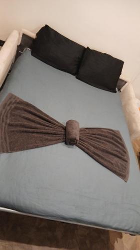 a bed with a brown bow tie on it at Luxury Studio - Romainville in Romainville
