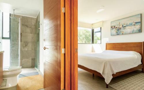 a bedroom with a bed and a shower and a toilet at CASA CON JACUZZI PRIVADO PARA 6 personas in Tequisquiapan