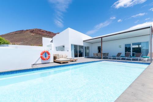 a villa with a swimming pool and a house at Ereza Hoopoe Villas in Playa Blanca
