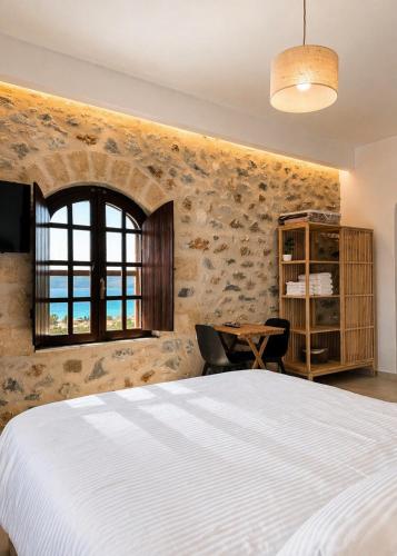 a bedroom with a large white bed and a desk at Papanestoras Apartments in Kardamyli