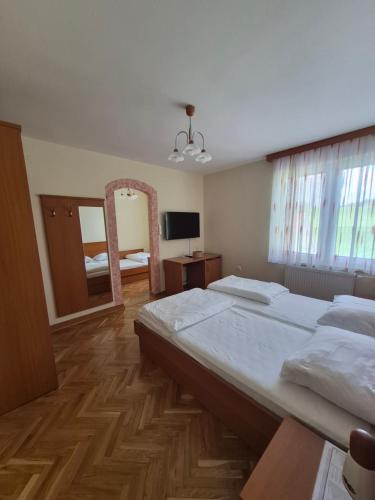 a bedroom with a large bed and a mirror at Gostišče Krka in Znojile pri Krki