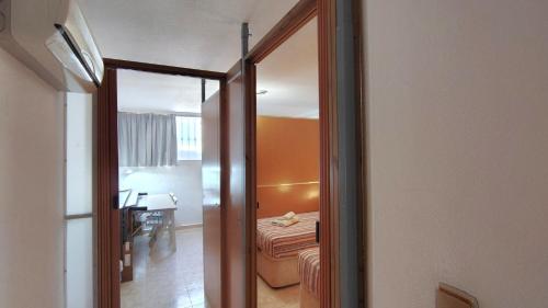 a hallway with a room with a couch and a mirror at Planta baja con piscina privada in Playas de Orihuela