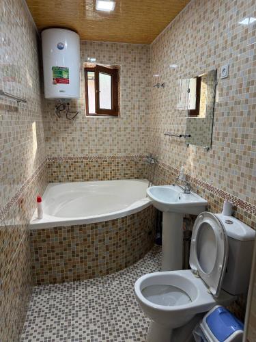 a bathroom with a tub and a toilet and a sink at Nurata Eco Guesthouse in Yukary-Ukhum