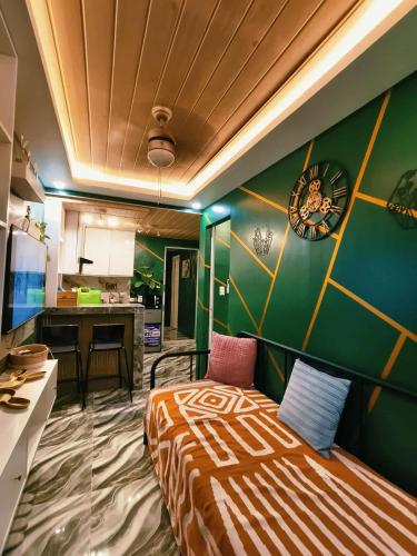 a bedroom with a bed and a green wall at Marcus Tiny House - Matcha in Cabanatuan City in Bangad