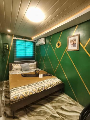 a bed in a room with a green wall at Marcus Tiny House - Matcha in Cabanatuan City in Bangad