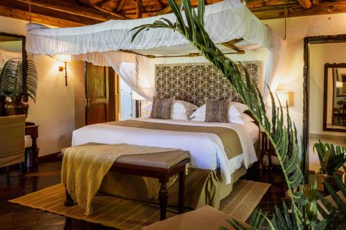 a bedroom with a bed with a canopy at The Palms Zanzibar in Bwejuu