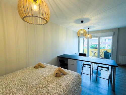 a bedroom with a bed and a table with chairs at Volcania Suites in Clermont-Ferrand