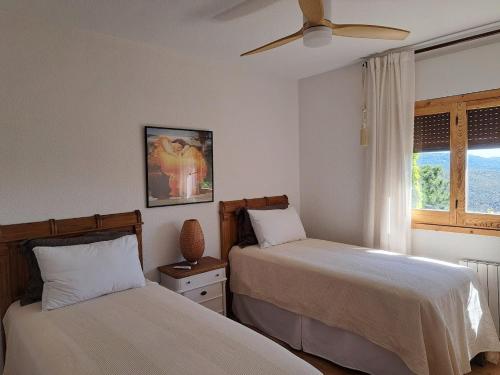 a bedroom with two beds and a ceiling fan at Casa Las Picoteras in La Estación