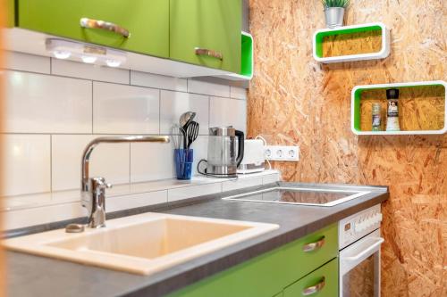 a kitchen with a sink and green cabinets at Bungalows im Grünen in Lychen